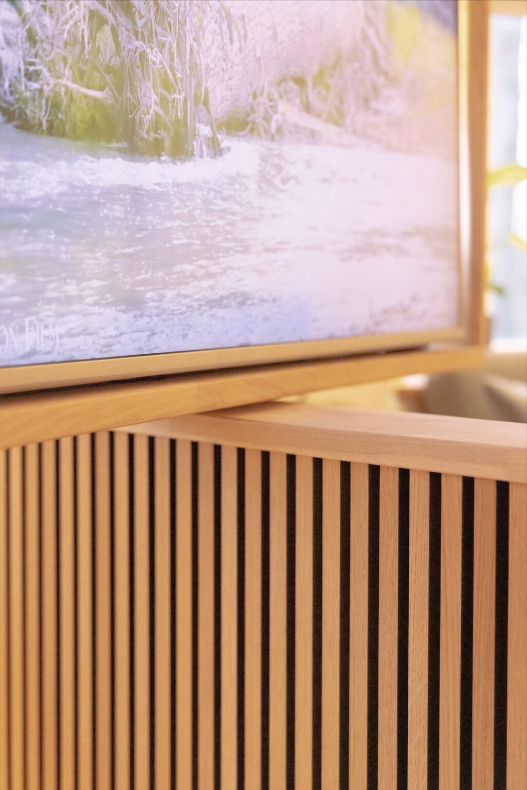 Wooden cabinet with nature-themed artwork above.